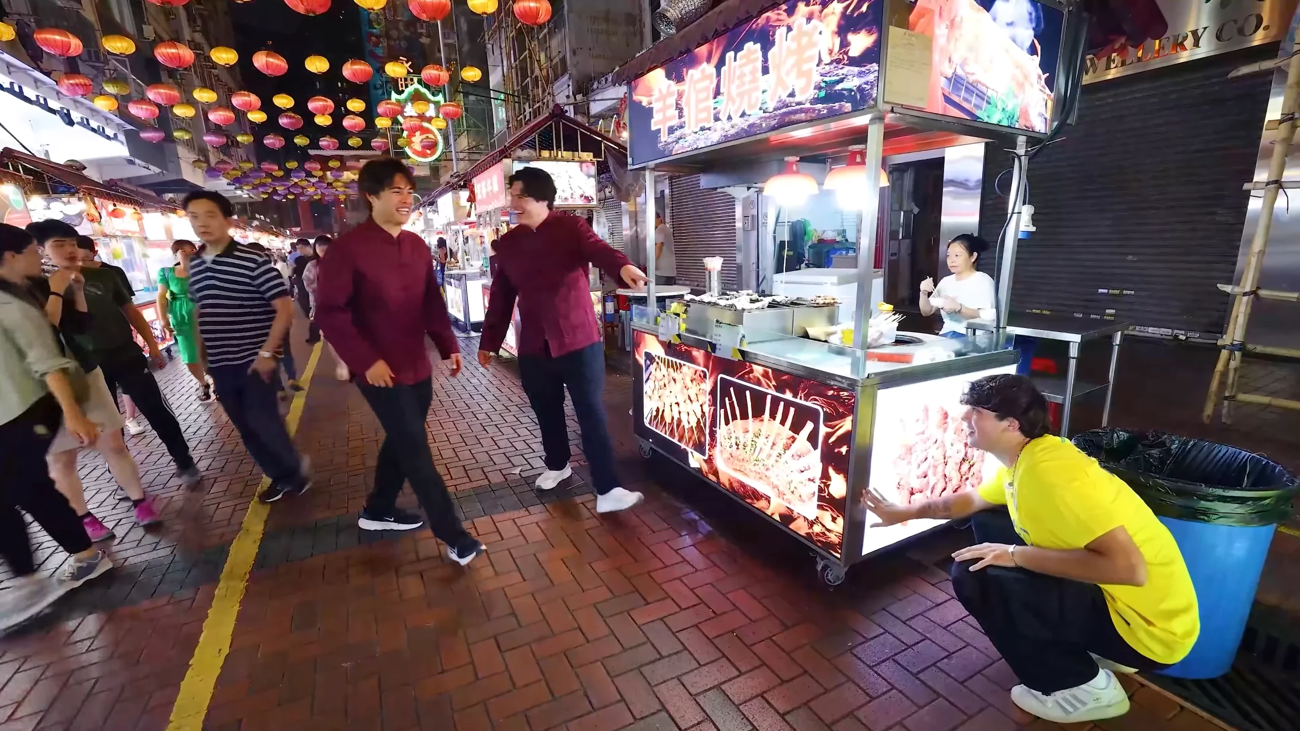 The Stokes Twins walking past Hong Kong night-market food stalls