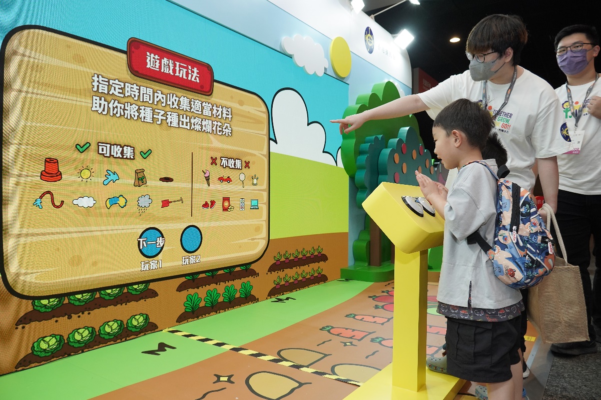 A child and adult exploring an interactive learning panel at the Hong Kong Book Fair