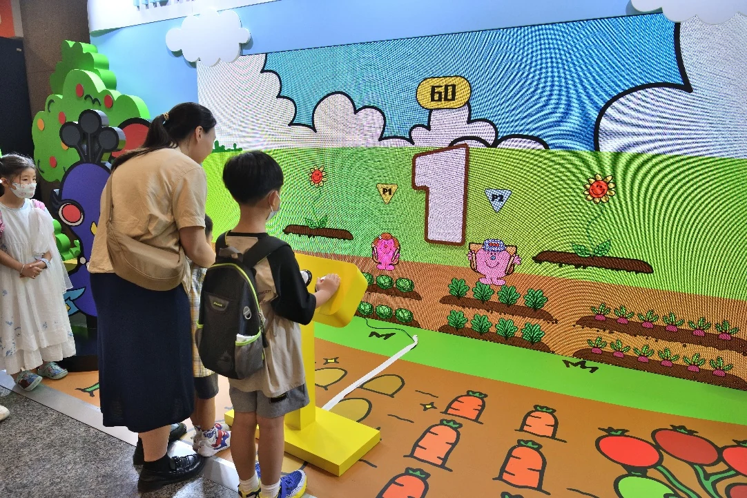 Families playing an interactive Mr. Men Little Miss video game at a public event